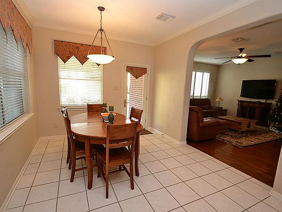 Breakfast room highlighted by tile floors, crown molding and a door to the covered patio area.