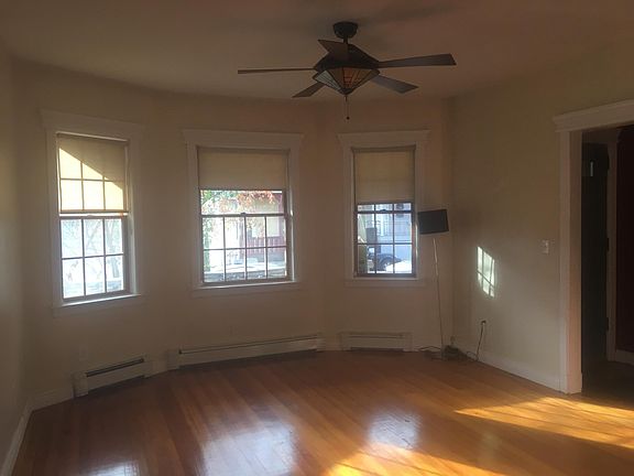 Open living room with windows and ceiling fan.