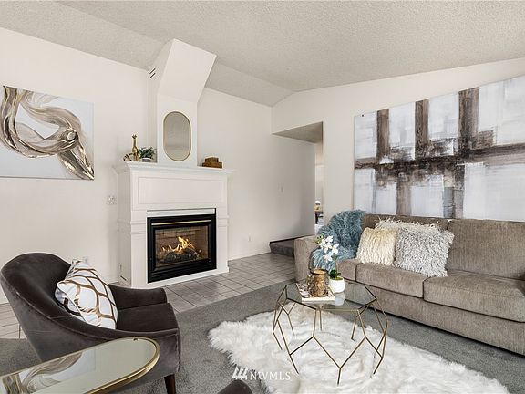 Formal living room with vaulted ceiling & natural gas fireplace.