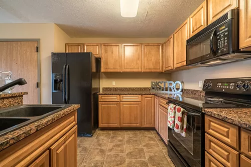 Kitchen with side-by-side refrigerator and abundant cabinet space. - The Grand Legacy