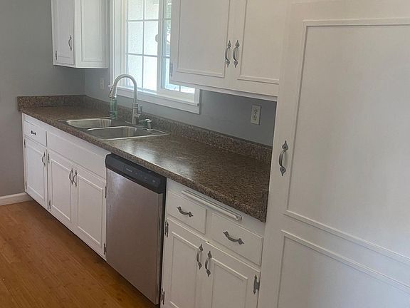 Bright and spacious kitchen with new countertops and freshly painted cabinets and walls with stainless steal stove, sink, and dishwasher