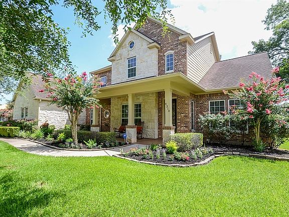 The front walkway meanders past lush landscaping to the welcoming front porch.