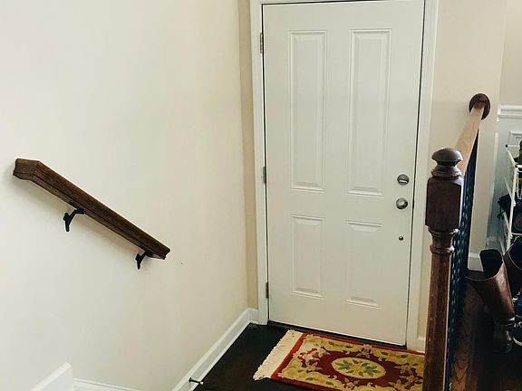 Steps leading up from the front door into the elevated living area. Original coffee hardwood floors throughout the main floor and hallways on all floors.