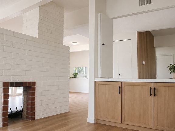 Rendering of updated den - new wood flooring, custom oak cabinetry, new paint