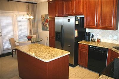 KITCHEN HAS A CENTER ISLAND WITH GRANITE COUNTER TOPS & CERAMIC TILE FLOORING