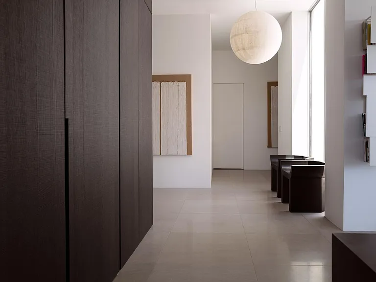 Refined Corridor with Custom Dark Paneling _ This sleek hallway showcases floor-to-ceiling cabinetry, modern lighting, and a neutral palette for a seamless, sophisticated flow.