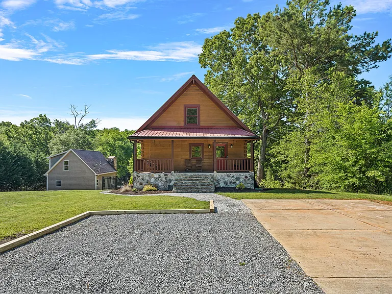 Front of the house. Cement parking pad can fit up to 4 vehicles and additional parking in adjacent gravel area.