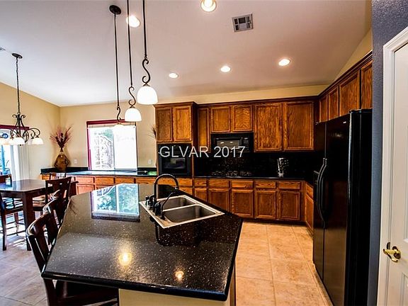 Upgraded kitchen boasting slab granite counter tops and built in oven