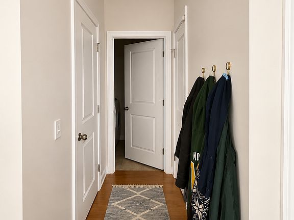small hallway to the right of the front door leads to the garage, laundry, and 1/2 bath for guests