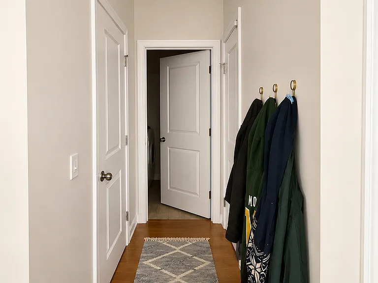 small hallway to the right of the front door leads to the garage, laundry, and 1/2 bath for guests