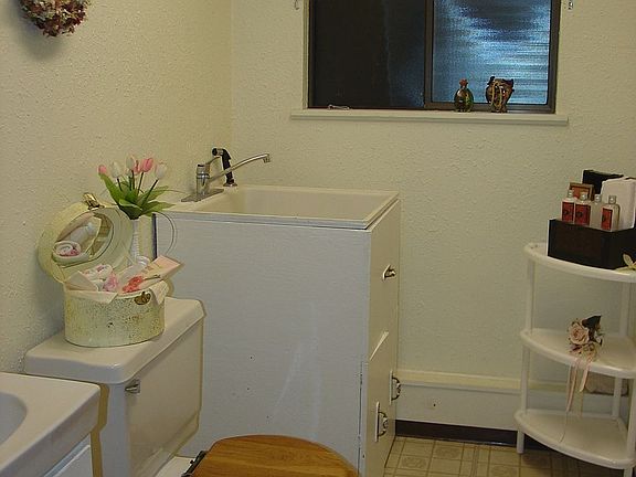 Bathroom on lower level with utility sink.