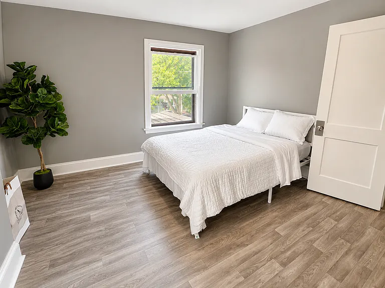 Spacious bedroom with updated flooring and natural light