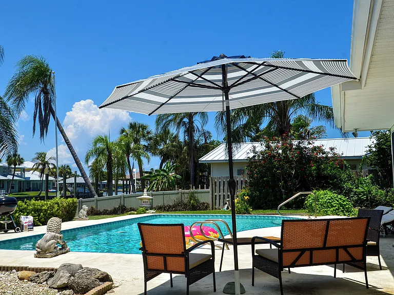 Heated pool with BBQ set, lounge chairs and seating