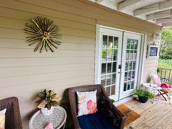 Front covered deck has comfy seating, footrests, and an epic view of river and bridge.
