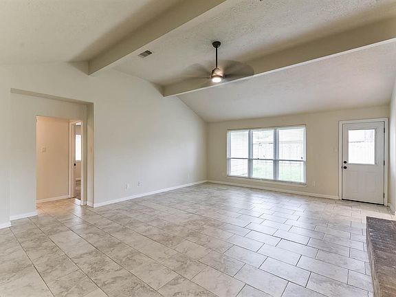21x17 Living Room - High ceiling, fireplace with brick surround and tile flooring.