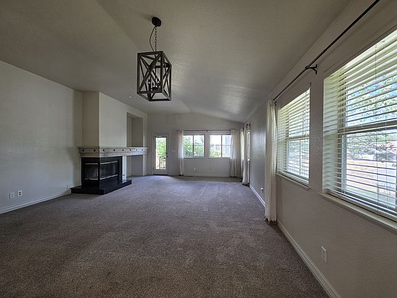 living room with gas fireplace, newer carpet, covered porch to mature treed back yard