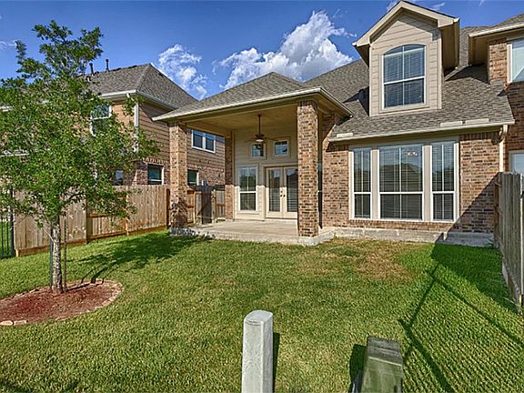 Pretty covered porch/covered back patio looks to water and has wrought iron fence