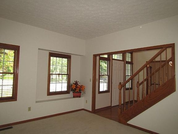 Interior foyer has wood floor. Stairs to 2nd floor. Hunter Douglas blinds on all windows in photos except for the high ones above the door. Room in photo is the living room, which is carpeted with Aged Silk off-white carpet, White Duck colored walls.