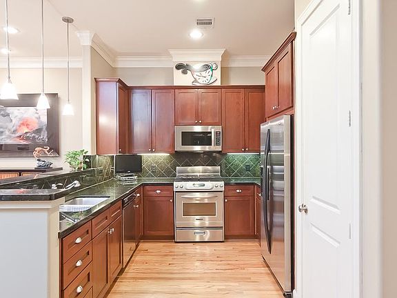 FIRST FLOOR-Chef's gourmet kitchen with upgraded cabinetry, slab granite counters and stainless steel appliances.