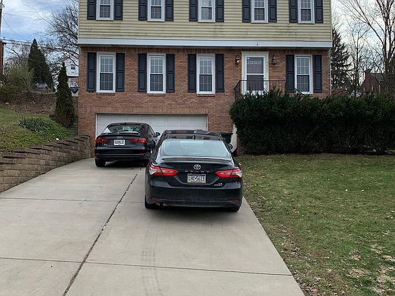 Front of the house, large brand new driveway and retaining wall.