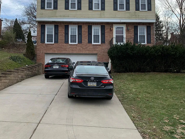Front of the house, large brand new driveway and retaining wall.