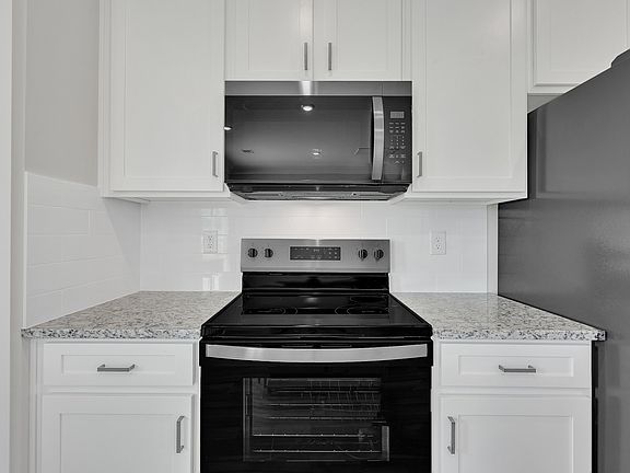 The kitchen has designer wood cabinetry.