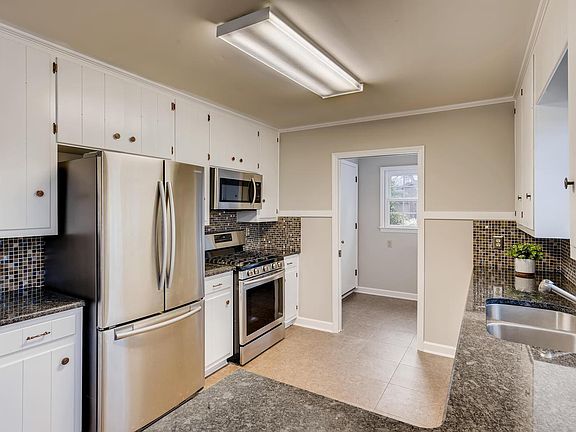 Kitchen has granite counters and stainless appliances, gas stove. Laundry room off of the kitchen has storage and a window.