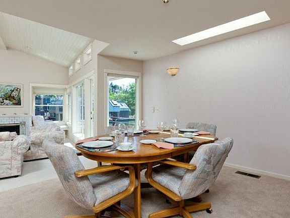 The spacious dining room with skylight is set up a step, allowing it to overlook the living room & to capture water views. A short stairway leads to the roof deck from this room.