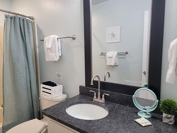 Granite counter, tall faucet, elongated toilet, tub with magnet convertible showerhead.