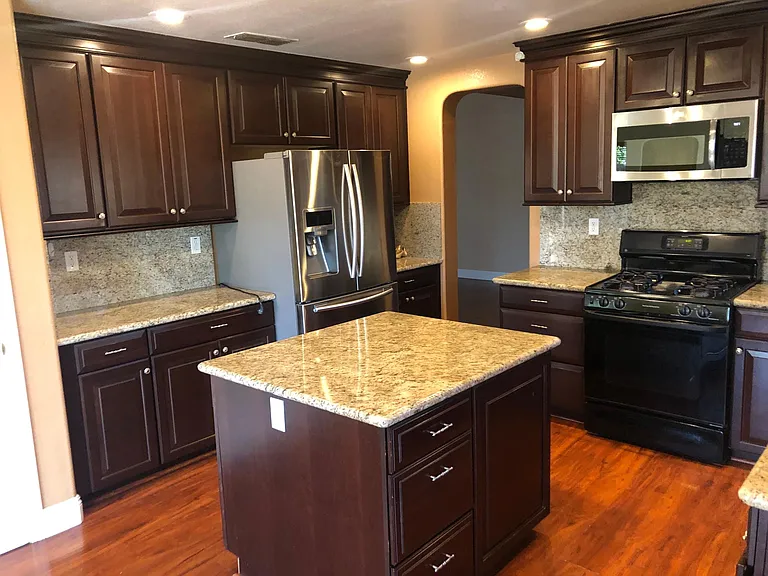 Kitchen with island, refrigerator, cooking range, oven, microwave oven.