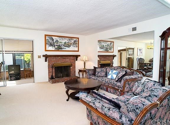 Th open and bright floor plan featuring the living room with fireplace.