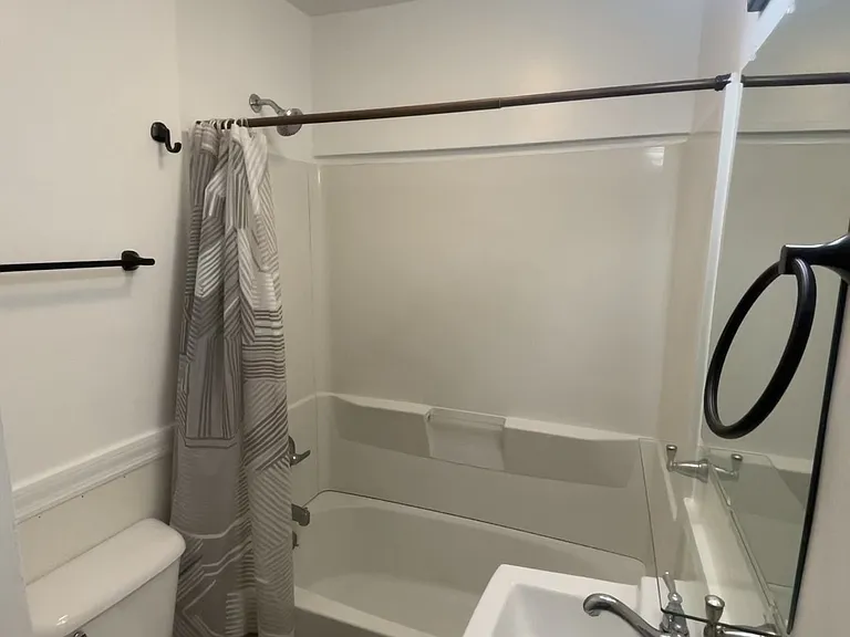 Bathroom fitted with: 
Tub/shower unit with shower rod, curtain & new liner.
Glass shelf above sink.
Wall mounted mirror with bright light bar above.
Overhead light fixture.
New exhaust fan.
Hand towel/bath towel hooks.
Built-in open air corner cabinet.
