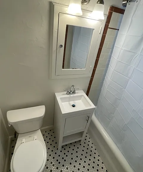 203 Bathroom has newer vanity, tile floors and lighting/hardware