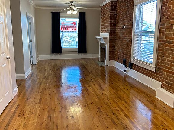 Large open and bright living/dining room with gleaming hardwood floors.