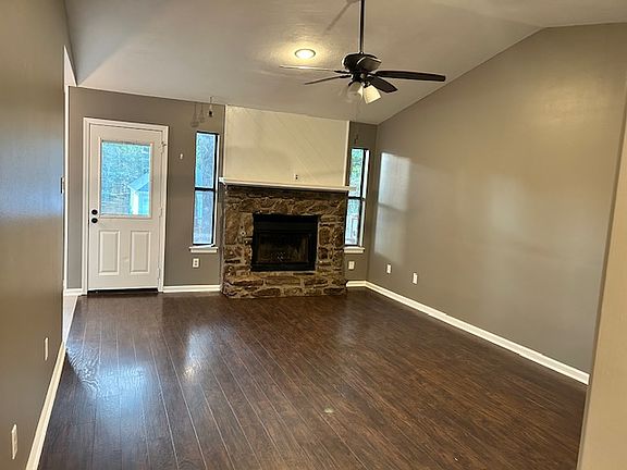 Living Room with Hard Wood floor and Fire place. Metal door with inbuilt blind leading to the Deck/Backyard