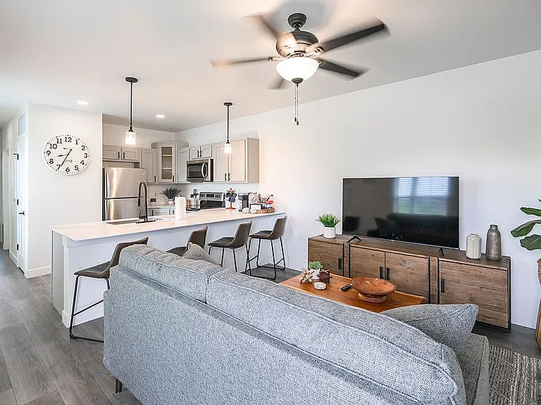 Contemporary open-plan living room and kitchen with modern furnishings and natural light, ideal for stylish living.