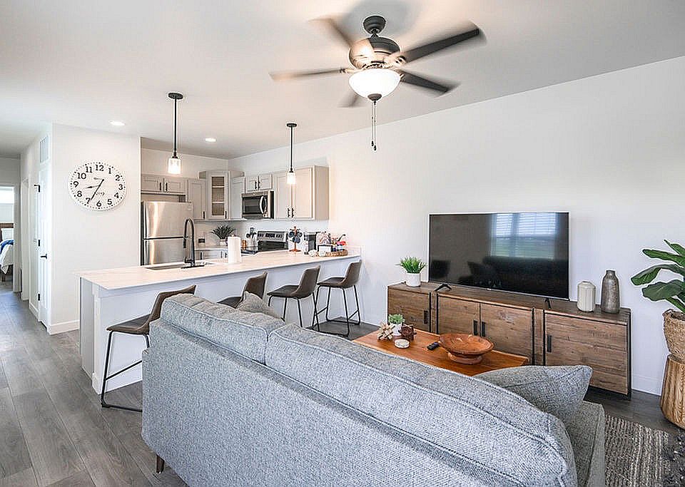Contemporary open-plan living room and kitchen with modern furnishings and natural light, ideal for stylish living.