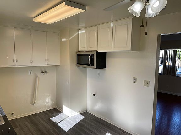 Kitchen east side showing cabinets, microwave and space for new range to be provided and refrigerator