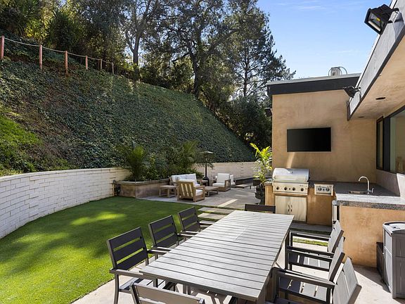 Enjoy al fresco dining in the private backyard, complete with outdoor furniture and a BBQ grill for unforgettable meals under the open sky.