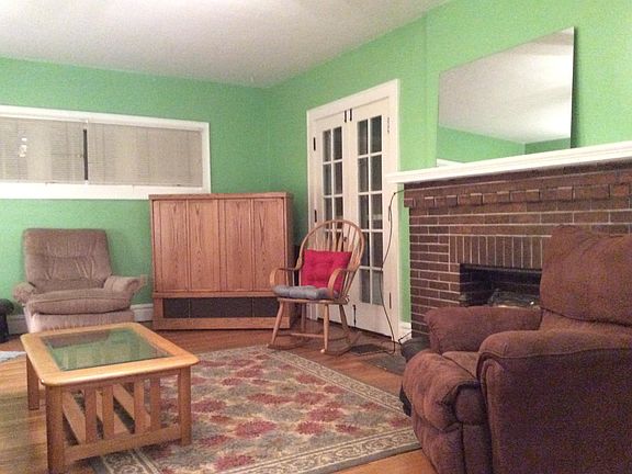 Large (13'x23') Living room looking northeast toward one of two sets of French doors on either side of fireplace to the outside porch viewed in foyer from an inside set of French doors.