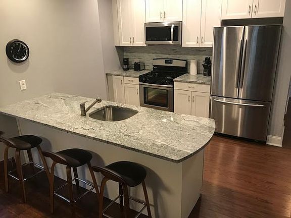 Spacious kitchen with granite counters and full-size stainless appliances and kitchen stools. 26 cu ft refrigerator with ice maker