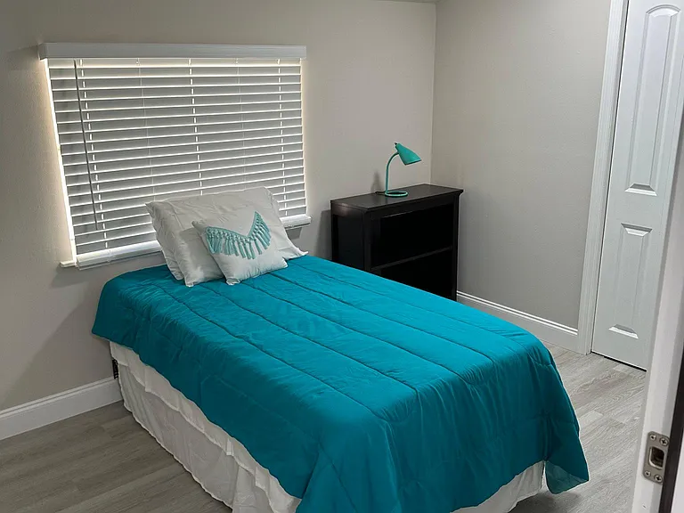 Small second bedroom with twin bed, dresser and closet.