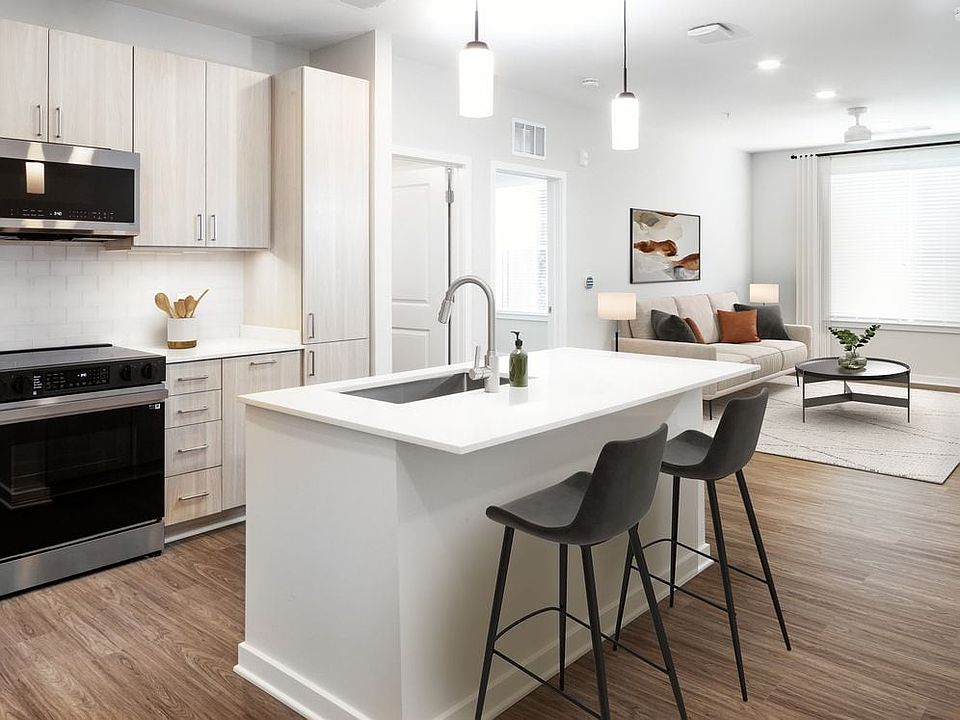 Upgrade Collection kitchen with stainless steel appliances, cream quartz countertops, oak cabinetry, and hard surface flooring (Representative photo)