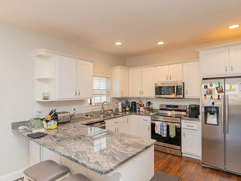 Kitchen features granite countertops, stainless steel appliances, and white custom cabinets