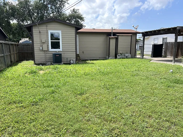 A large yard with green grass, perfect for the doggies (or kitties)