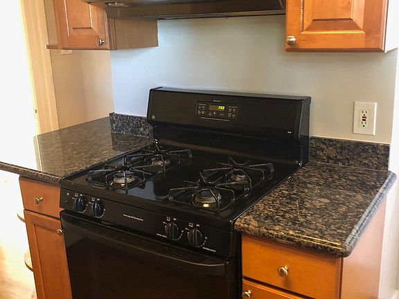 Gas stove, granite countertops and hardwood floors in kitche
