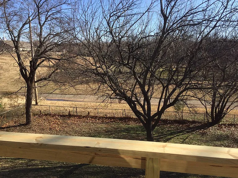 view of back yard from balcony and open church property behind the house