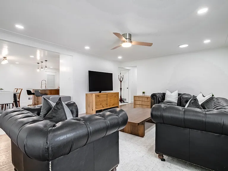 Spacious living room with fan and plenty of lighting. Hardwood floors & open to dining space- perfect for entertaining.