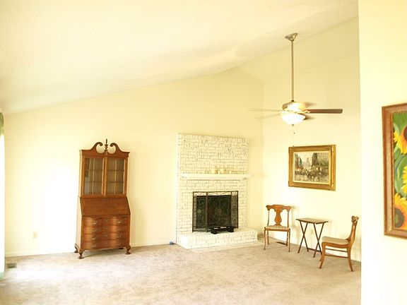 spacious living room with vaulted ceiling and wood burning fireplace