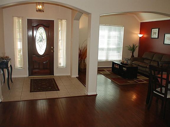 Leaded glass ornate wood door opens to Bruce wood flooring entry foyer